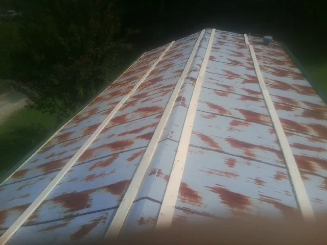 Rusted metal roof panels with new wood purlins before replacement — Storm Damage Roof Repair in Lusby by Roofing Brothers