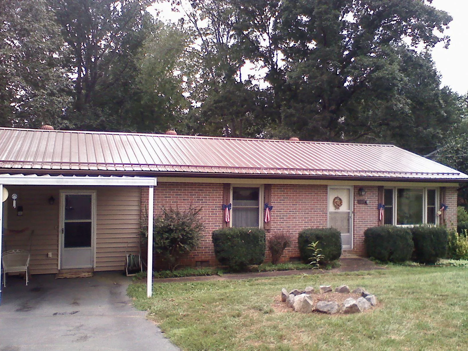 Bronze metal roof and carport on a brick ranch home — Roof Repair work by our crew in Lusby