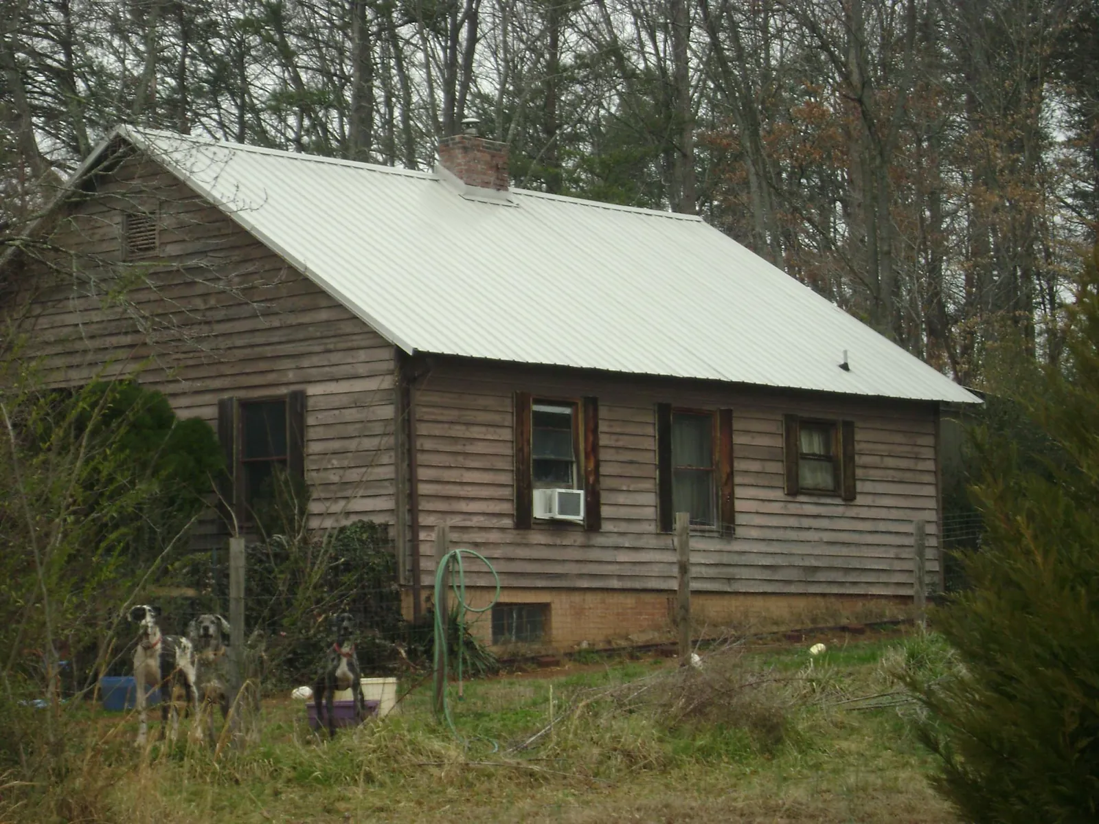 White metal roof on an old wood sided farmhouse, from a Metal Roof Installation job in Lusby